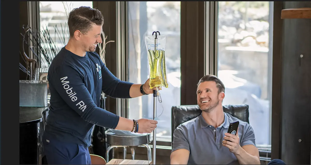 An Intravene mobile RN hanging an IV drip for a client in their living room